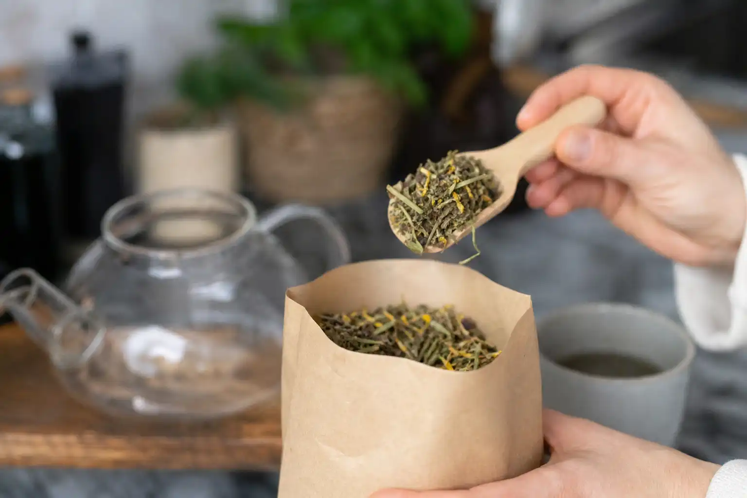 Des mains dosent quelque chose, autour de tisane cbd sommeil, dans une cuisine.